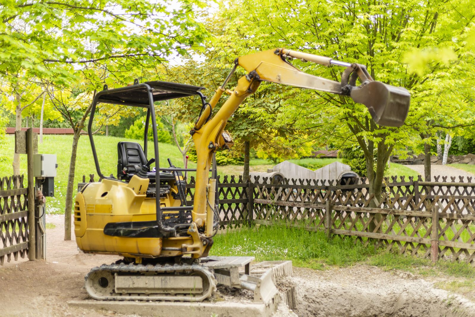 Minibagger hebt im Garten einen Graben aus